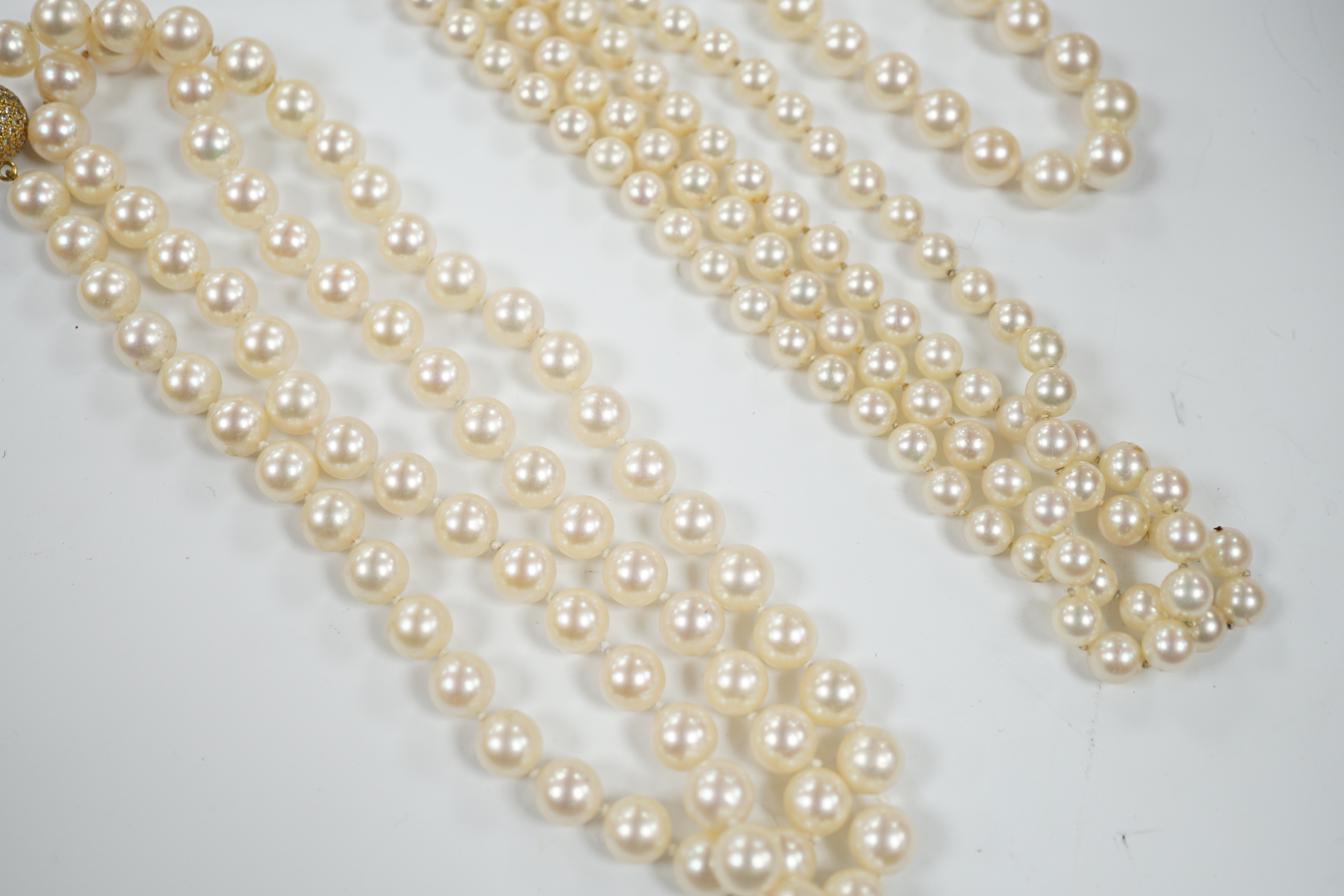 A single strand cultured pearl necklace, with diamond chip set 18ct gold clasp, 74cm and similar bracelet with diamond mounted clasps together with another cultured pearl necklace.